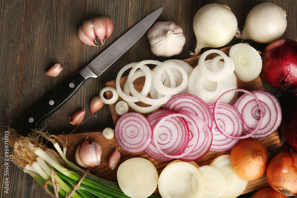 Composition of onions and garlic on wooden background