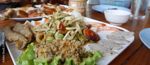 Spicy papaya salad serving with shrimp, boiled egg, porkball and photo