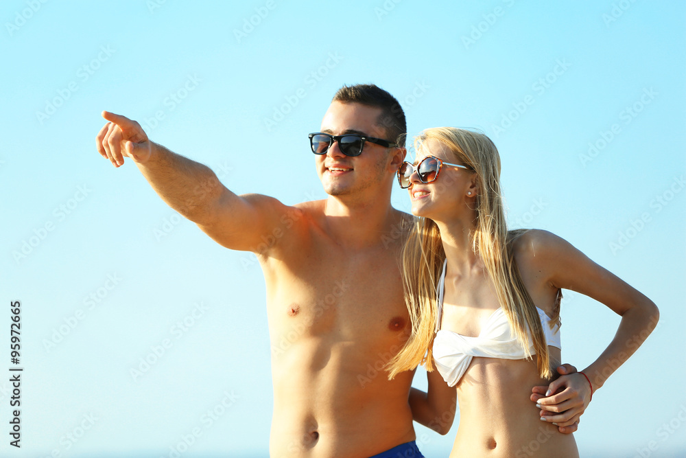 A hugging couple at the beach, on sky background A hugging couple at the beach, on sky background