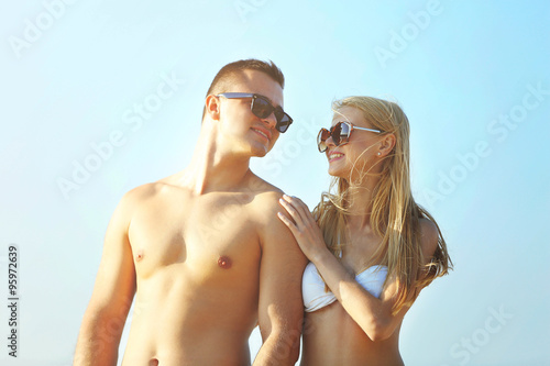 A happy couple relaxing at the beach, on sky background