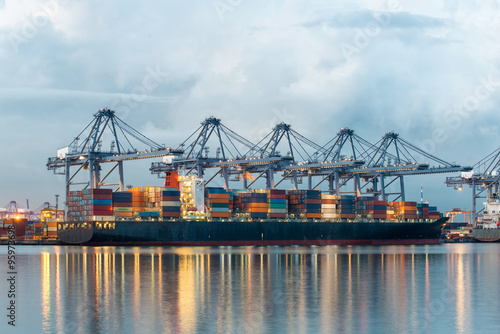 Container Cargo freight ship with working crane bridge in shipya