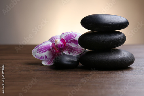 Black pebbles with orchid on wooden table