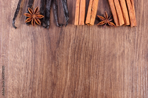 Vanilla, cinnamon sticks, anise on wooden surface, copy space for text