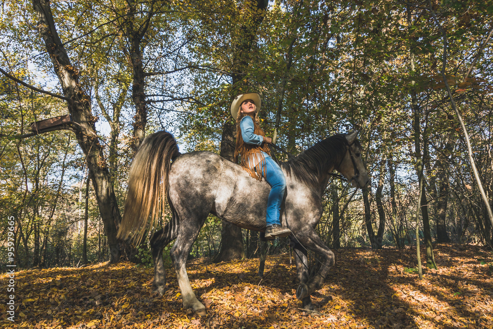 Pretty girl riding her grey horse