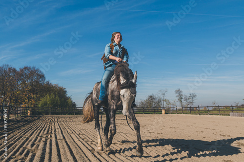 Pretty girl riding her grey horse