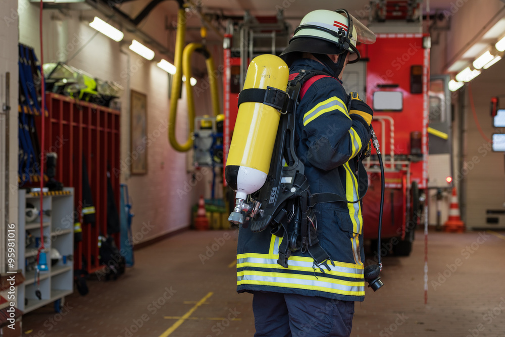 Feuerwehrmann mit Sauerstofflasche auf dem Tücken Feuerwehrmann mit Sauerstofflasche auf dem Tücken
