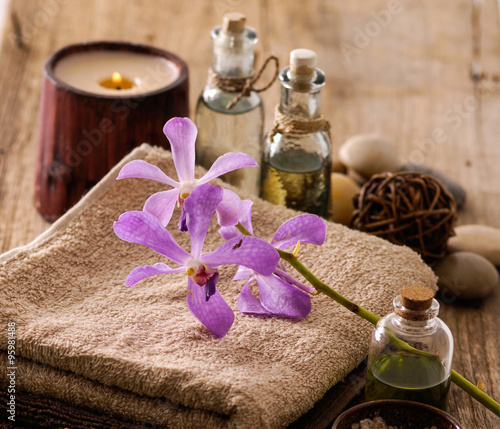 Bath spa on old wood with orchid on towel photo