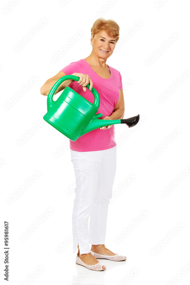 Smiling senior woman with green watering can Smiling senior woman with green watering can