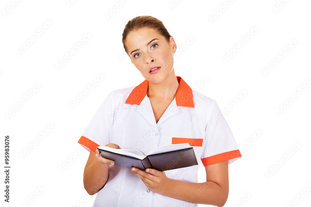 Young focus female doctor or nurse makes notes Young focus female doctor or nurse makes notes