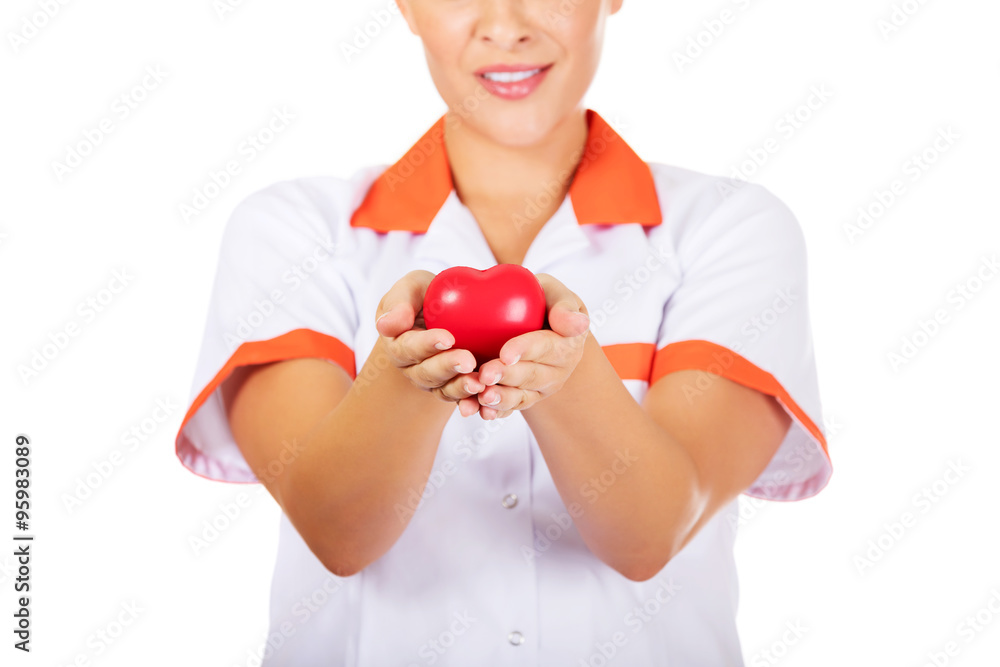 Young female doctor or nurse holding toy heart Young female doctor or nurse holding toy heart