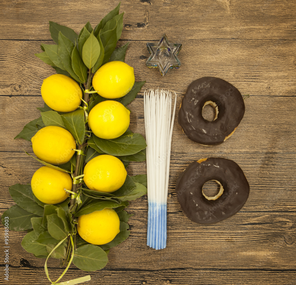 Branch lemons donuts candles crown of thorns and goat horn. Symbols of the great holiday of Hanukkah. On wooden background. Branch lemons donuts candles crown of thorns and goat horn. Symbols of the great holiday of Hanukkah. On wooden background.
