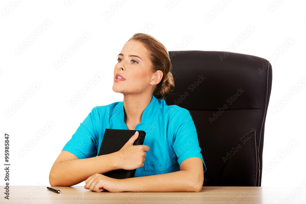 Doctor sitting behind the desk and thinking about something Doctor sitting behind the desk and thinking about something