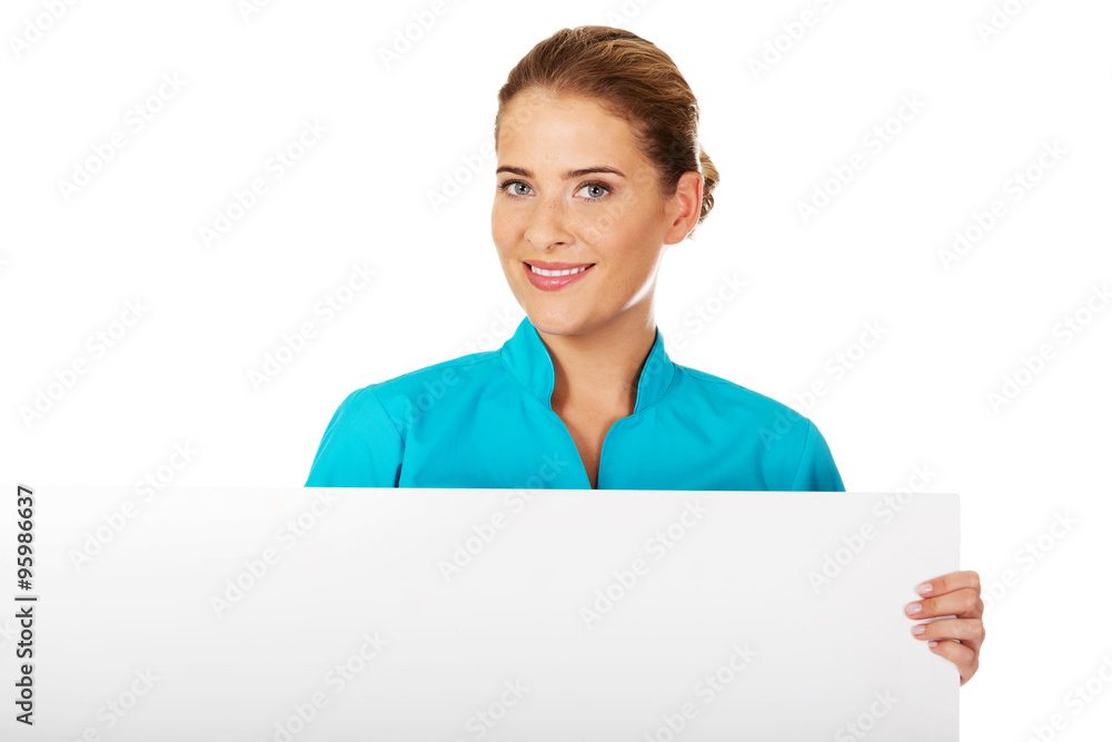 Young female doctor or nurse holding empty banner Young female doctor or nurse holding empty banner
