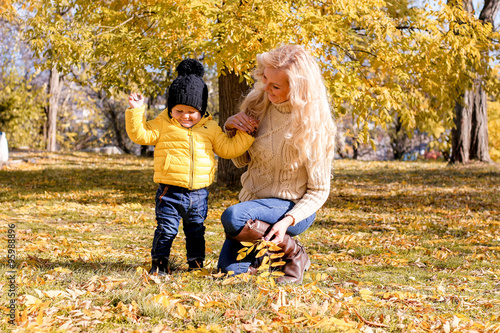 Mother and son walking in the autumn park photo