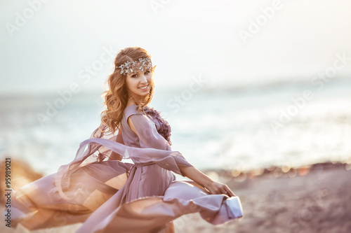 Portrait of a girl in a fairy light dress on a sunset