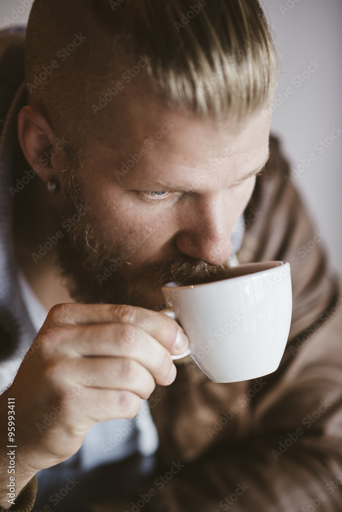 portrait of handsome bearded man drinking coffee