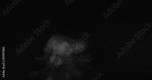Puff of particles amid suspended atmospheric dust studio shot