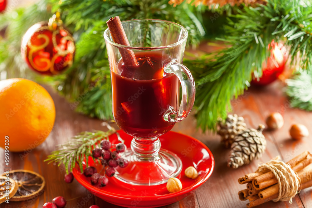 Holiday winter hot drink. Mulled wine with fruits and spices by Christmas tree with decorations. Holiday winter hot drink. Mulled wine with fruits and spices by Christmas tree with decorations.