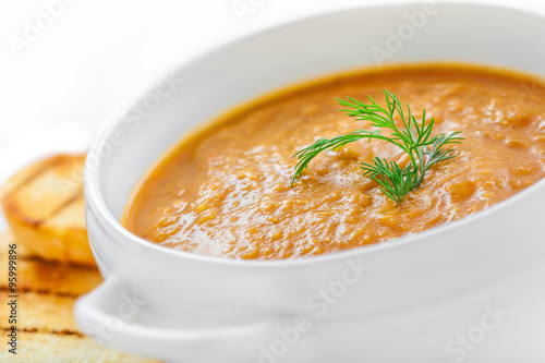 Bowl of lentil cream soup with toasts, close-up