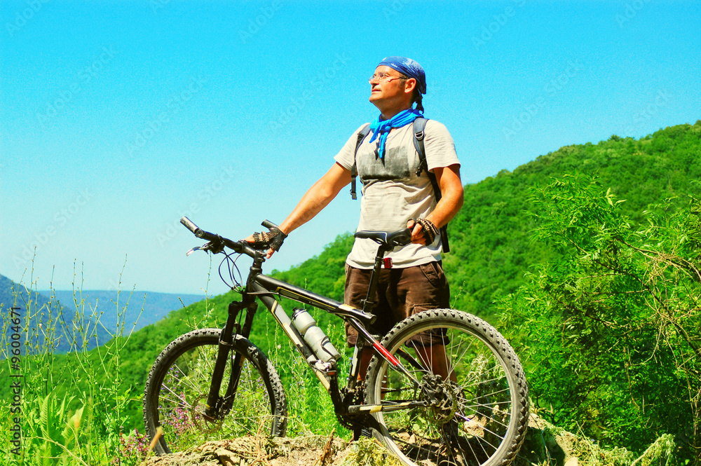 Cyclist and his bicycle on a hill