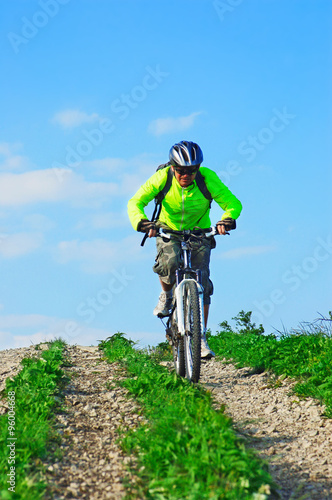 Cyclist rides downhill from mountain