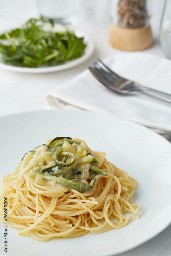 a plate of pasta with zucchini