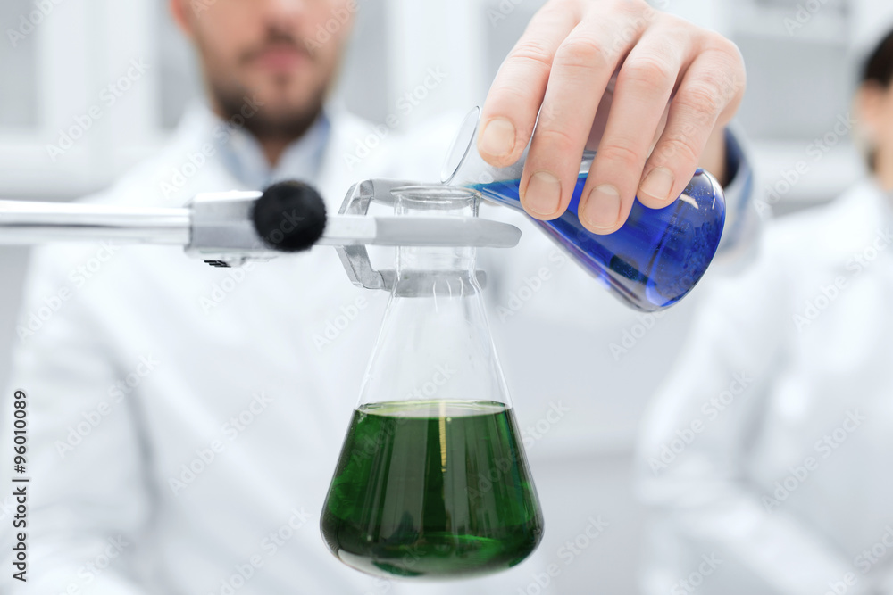 close up of scientist filling test tubes in lab close up of scientist filling test tubes in lab