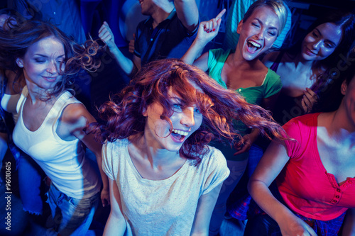 smiling friends dancing in club