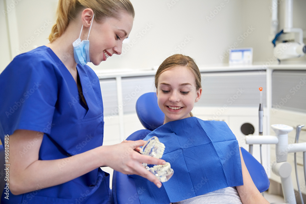 happy dentist showing jaw model to patient girl happy dentist showing jaw model to patient girl