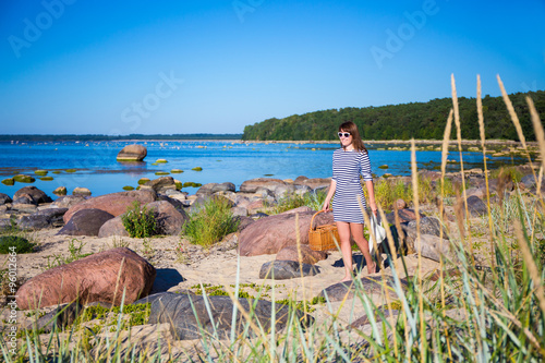 beautiful woman walking on the beach with picnic basket