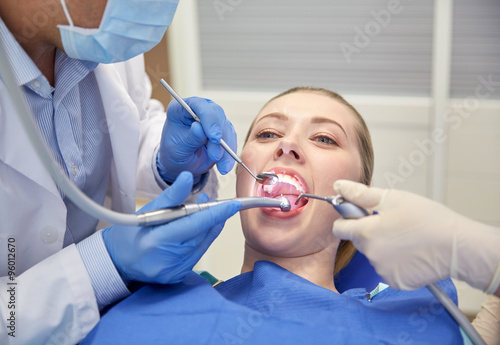 close up of dentist treating female patient teeth