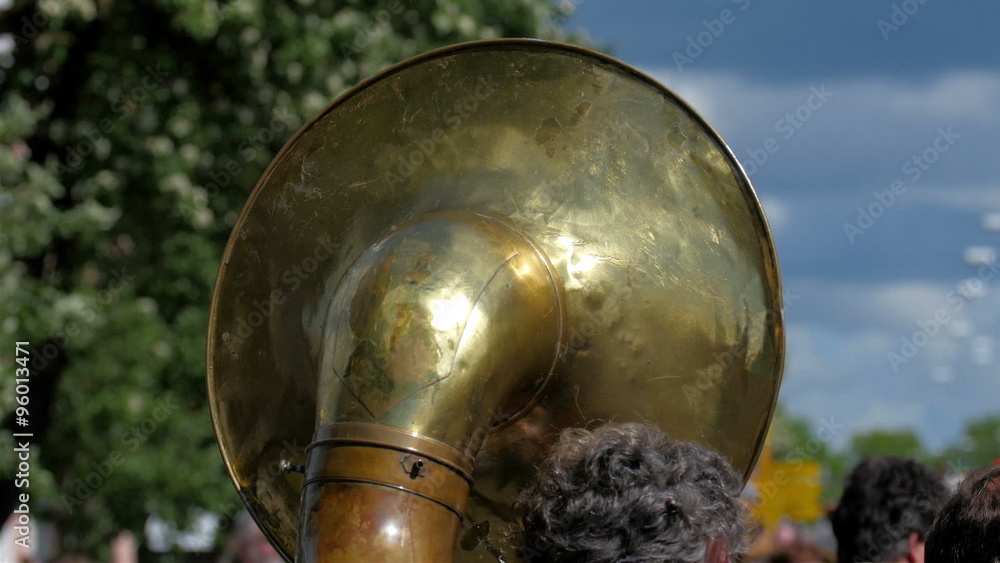 The back of a big tuba in a band. The tuba is the largest and lowest