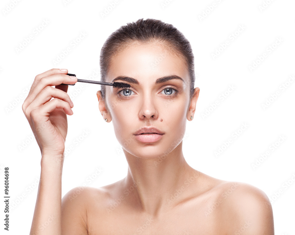 woman applying mascara makeup on eyes by brush woman applying mascara makeup on eyes by brush