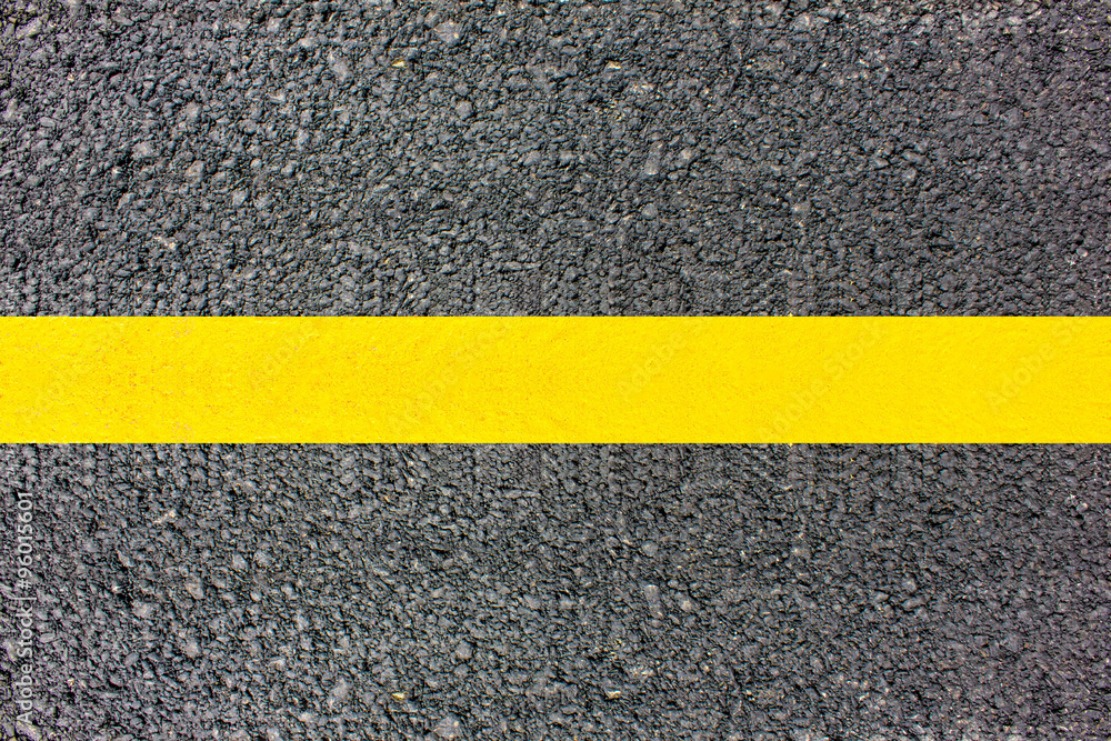 Asphalt surface of the road with a yellow line.