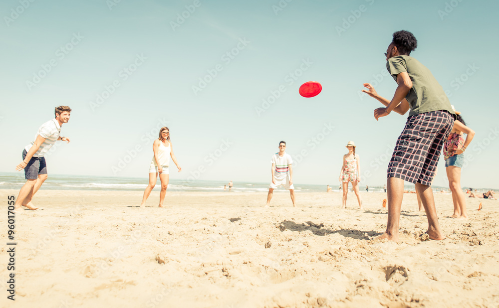 Group of friends playing with frisbee on the beach Group of friends playing with frisbee on the beach