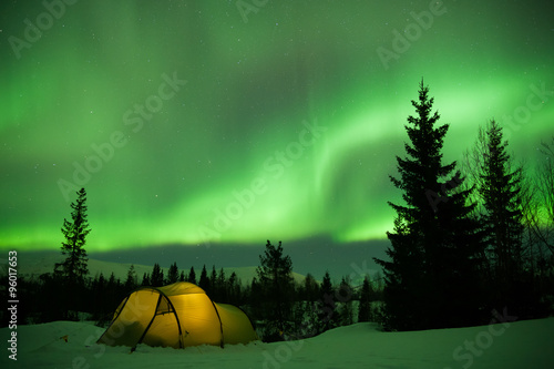 beleuchtetes Zelt mit Nordlichtern im Hintergrund 