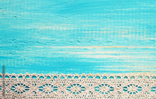 Turquoise shabby painted wooden empty background with lace border. Toned. 