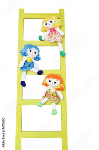 Three funny doll on a wooden ladder