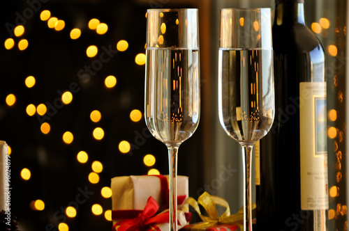 two champagner glasses on glass table with black bokeh background