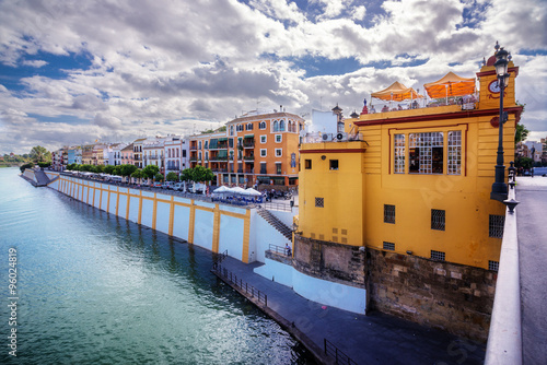 The old Triana lighthouse and the colorful houses of the riverbank of the Guadalquivir in Seville, Spain photo