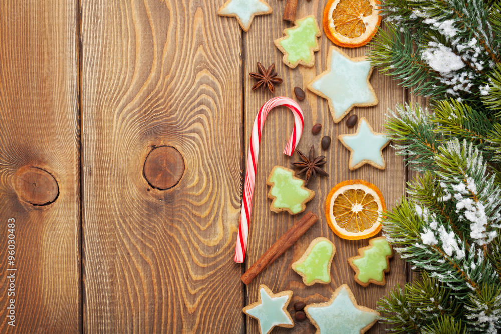 Christmas wooden background with snow fir tree, spices, gingerbr Christmas wooden background with snow fir tree, spices, gingerbr