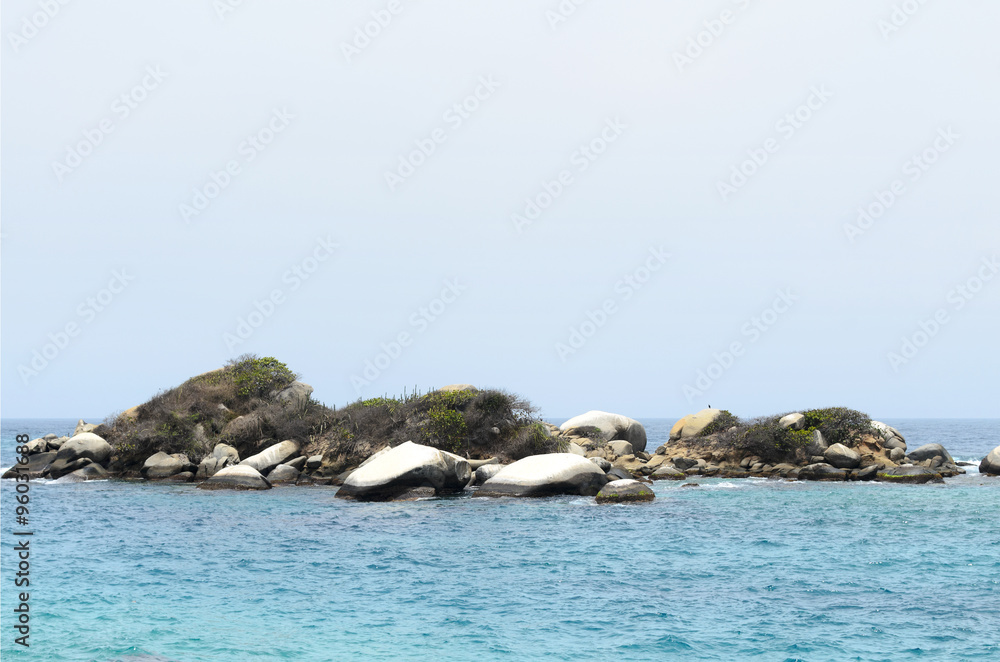 Fototapeta premium Little rocky island surrounded by turquoise sea water