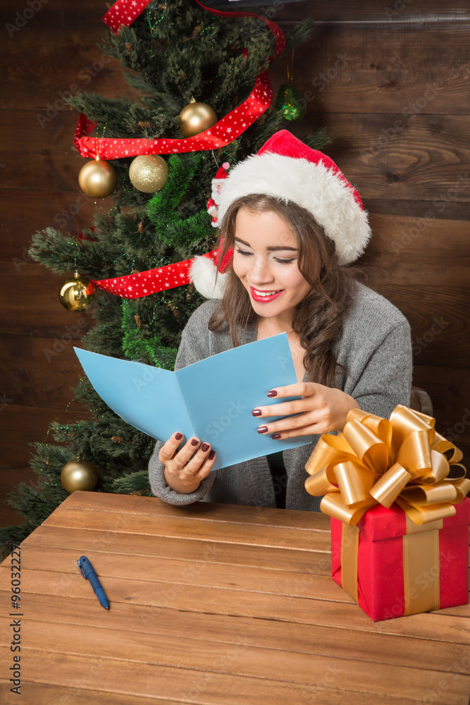 Beautiful girl reading New Year and Christmas congratulation Beautiful girl reading New Year and Christmas congratulation