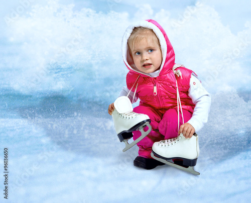 Portrait of little girl holds skates on an abstract background
