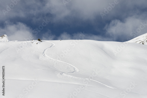 Snowboard trail on virgin snow powder alpine landscape