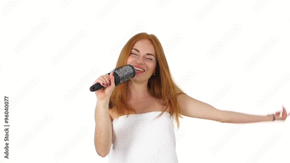 Young girl singing using a brush as a microphone, slow motion, bathroom Young girl singing using a brush as a microphone, slow motion, bathroom