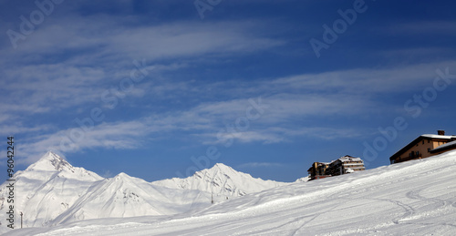 Panoramic view on ski slope and hotels in winter mountains