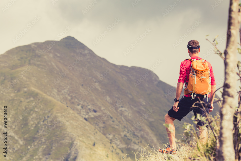 Hiking man with backpack in mountains