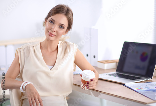 Beautiful businesswoman enjoying coffee in bright office