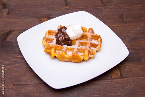 waffles with chocolate cream on wooden table